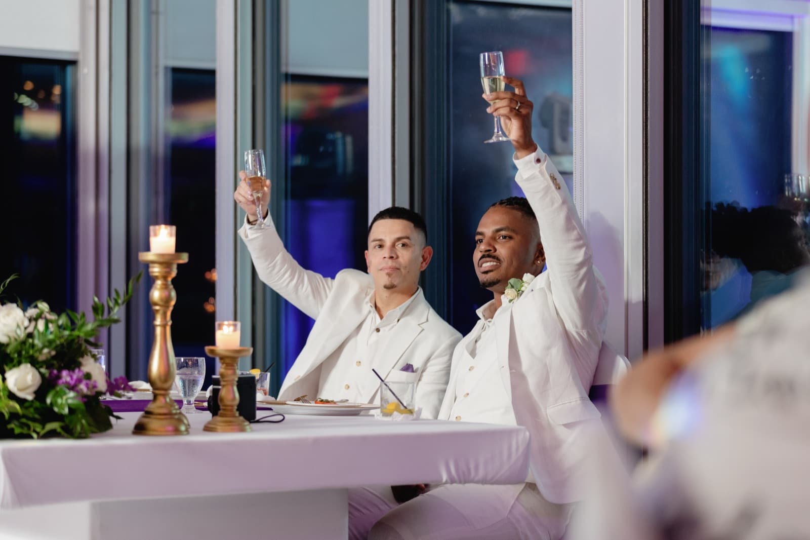 Moises and Cesar celebrating at their wedding, surrounded by family